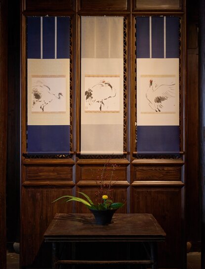 Wooden wardrobe with blue-framed panels and decorative artwork in the main hall at Amanfayun.
