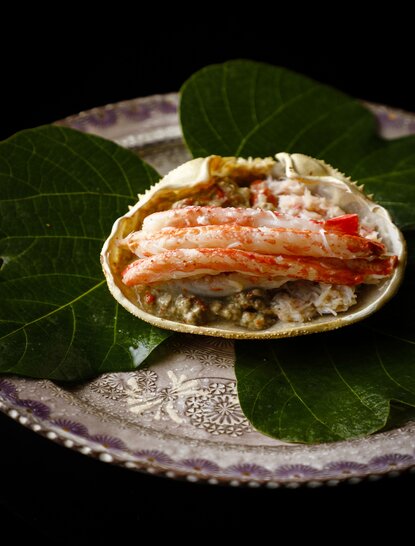 Snow crab served on a shell at Aman Kyoto, garnished with fresh leaves.