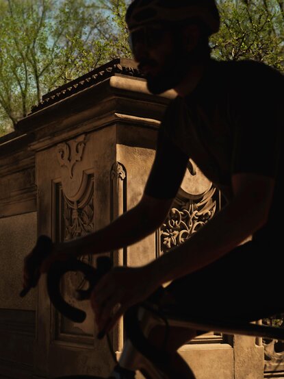 Cyclist's silhouette against golden light at Aman New York.