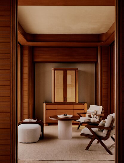 Casita living area with warm wood panelling, modern chair and soft furnishings at Amanvari, Mexico.