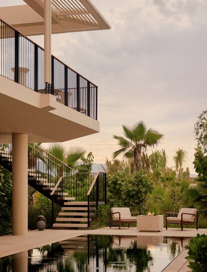Casita exterior at Amanvari with palm trees and courtyard pool at dusk.