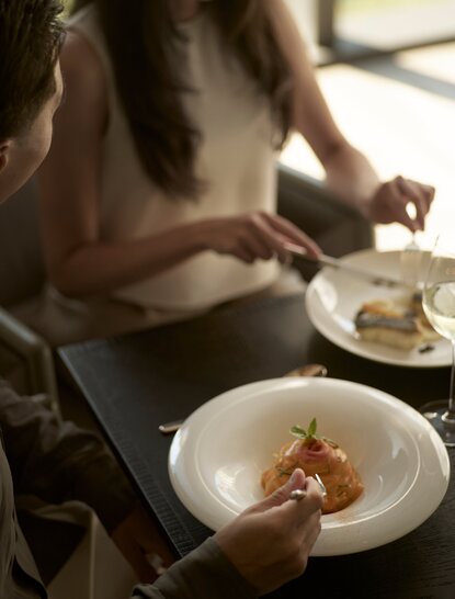Diner with a plate of Thai cuisine at Aman Nai Lert Bangkok