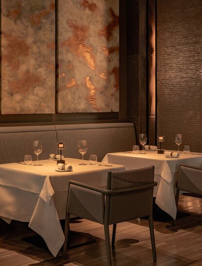 Two dining tables set with white linens at Aman Nai Lert Bangkok, Thailand.