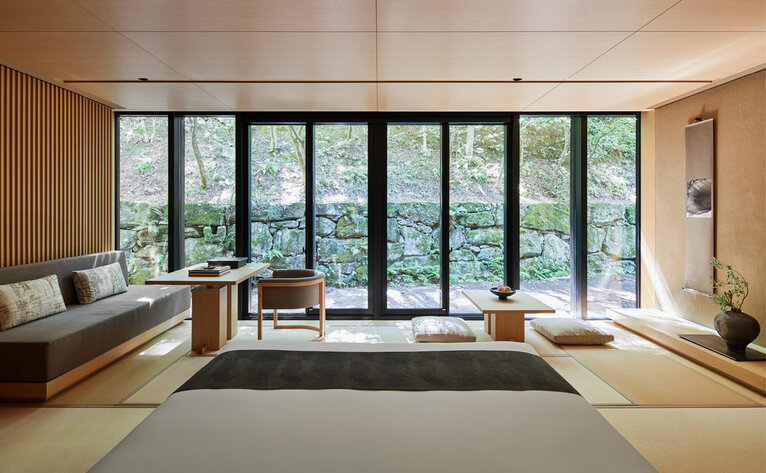 Interior de baño con ventanales que dan a jardín en Aman Kyoto resort.