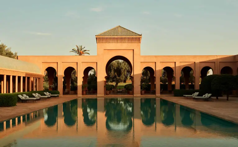 Bassin central encadré de colonnades et de pavillon en architecture marocaine traditionnelle à Amanjena.