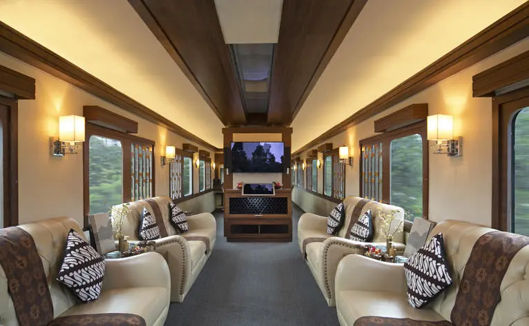 Amanjiwo resort's private train carriage with rows of seated chairs and warm lighting.