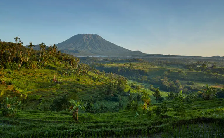 Terraced rice fields and Mount Agung at Amankila resort, Bali, Indonesia.