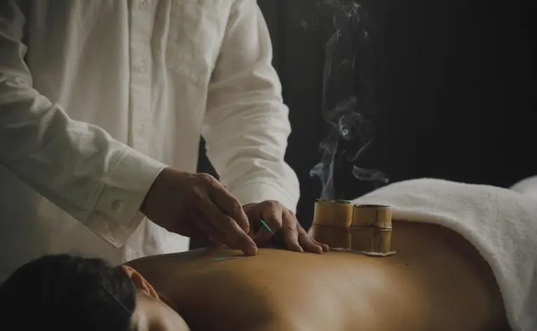 Practitioner administering acupuncture treatment at Aman Kyoto resort.