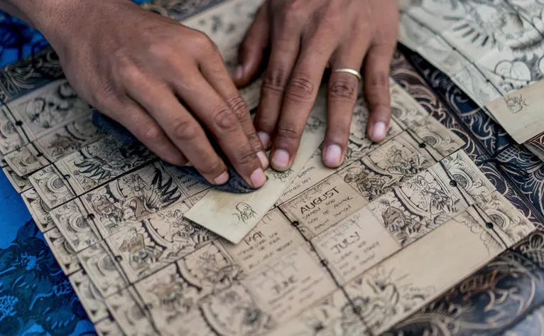 Hands examining architectural plans at Amankila