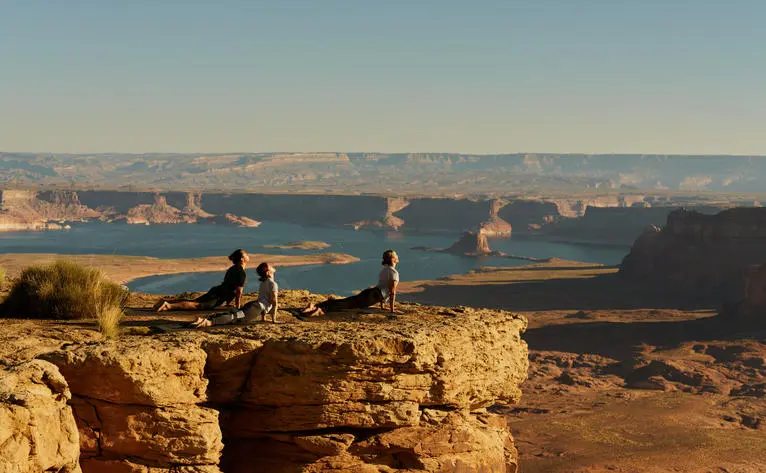 Deux personnes pratiquant le yoga face aux formations rocheuses du Grand Canyon à Amangiri, resort en Arizona.