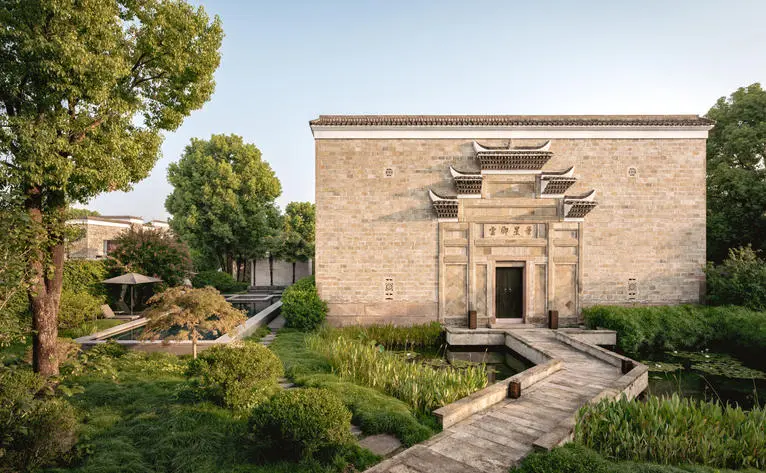 养云安缦度假村的四卧室古董别墅外观，砖砌建筑坐落于郁郁葱葱的花园中。