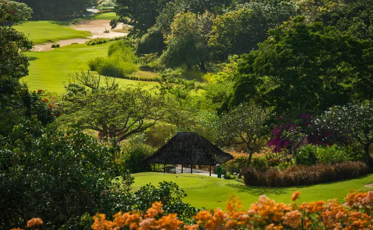 Golf course tee at Aman Villas at Nusa Dua, surrounded by lush greenery and tropical vegetation.
