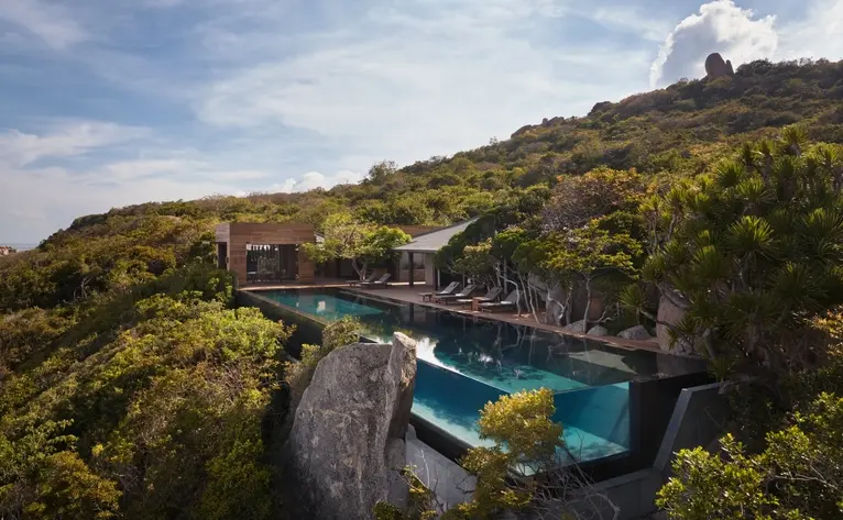 Amanoi resort ocean pool residence with infinity pool overlooking Vietnamese coastline and forested hillside.