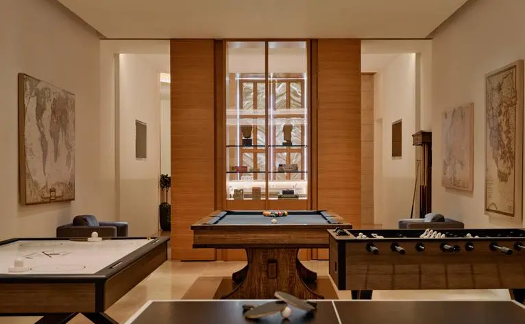 Games room at Amanzoe with wooden billiards table and classical artwork.