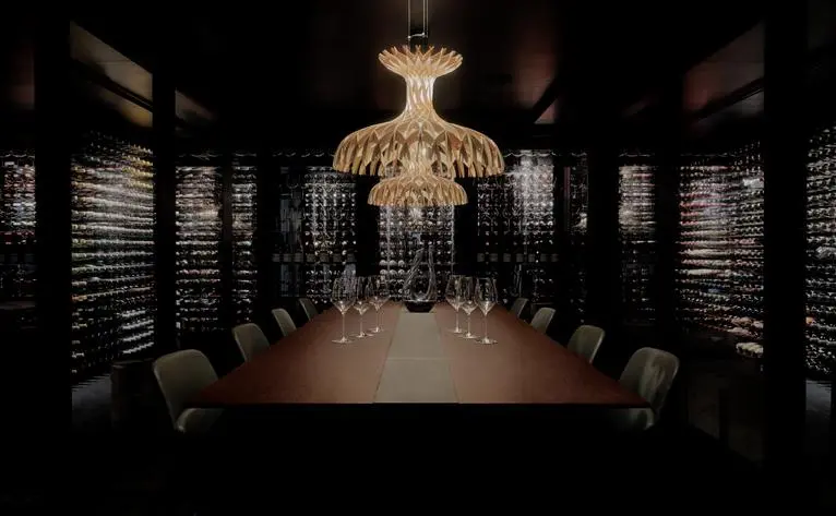 Di Vino Room at Aman Rosa Alpina, Italy, with ornate chandelier and wine displays.