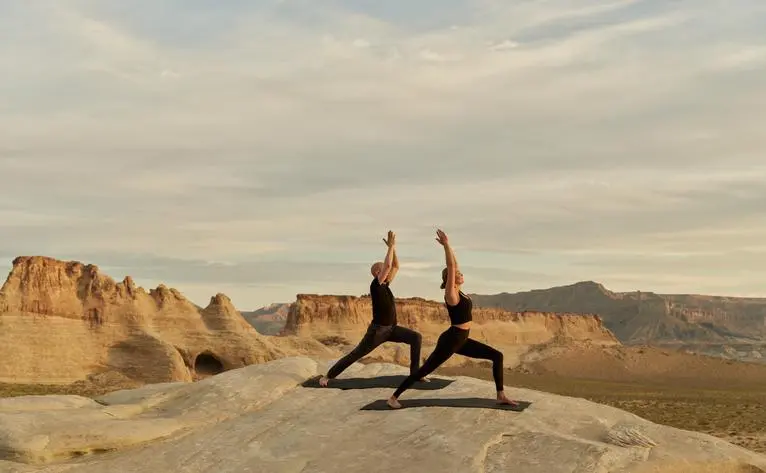 Yoga session on desert rocks at Amangiri resort, Utah.