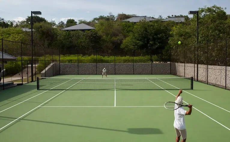 Amanoi tennis court at the Vietnam resort with a player on the green court.