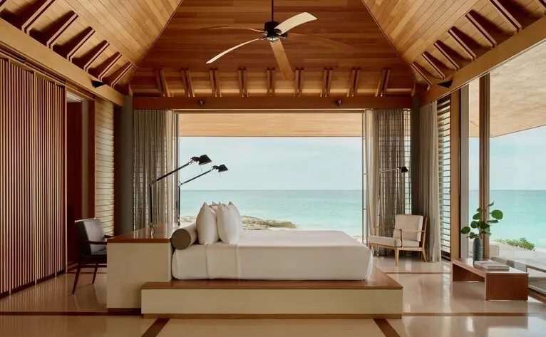 Villa 33 spa bath at Amanyara with ocean views through open wooden doors.