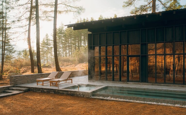 Spa House at Amankora's Paro Lodge with steaming pool and forest views at dusk.
