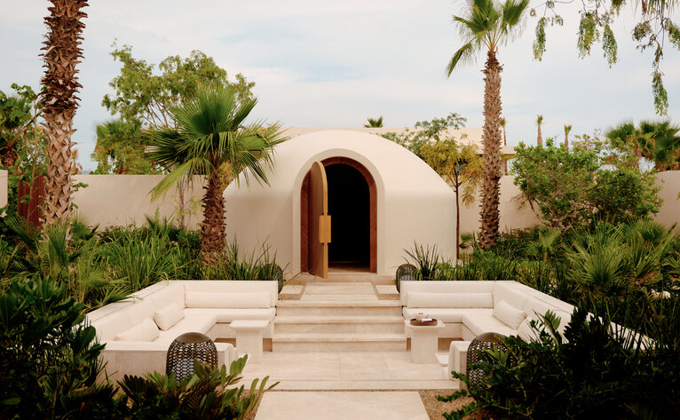 Temazcal steam bath at Amanvari, Mexico, with curved adobe walls and arched entrance surrounded by desert plants.