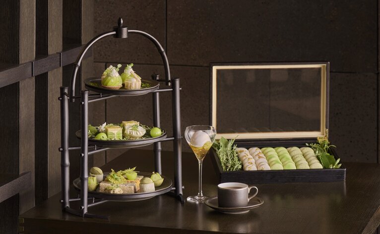 Aman Tokyo lounge display with tiered stand of citrus fruits and open wooden box of produce.