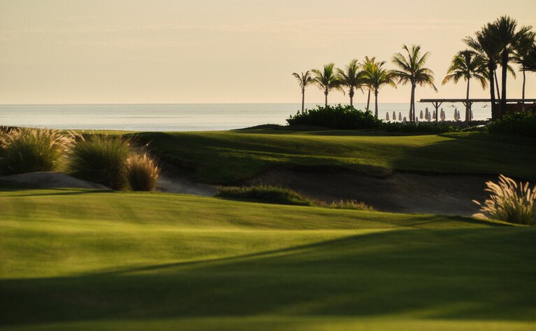 Manicured golf fairway with palm trees and coastal views at Amanvari, Costa Palmas.