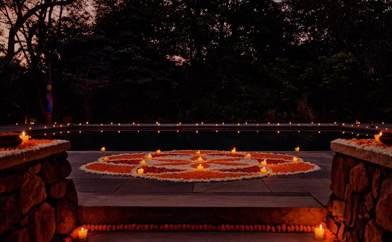 Pool dinner with musicians at Aman-i-Khas, India, lit by warm candlelight at dusk.