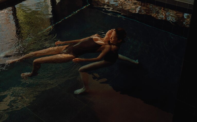 Person floating face-up during a Watsu water therapy session at Amanemu spa in Japan.