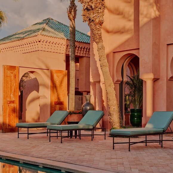 Villa terrace at Amanjena resort in Morocco with turquoise seating and warm ochre architecture.