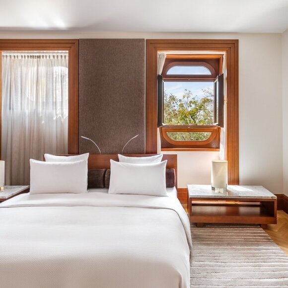Queen Marija Suite bedroom at Aman Sveti Stefan with bed, wooden frames and coastal views.