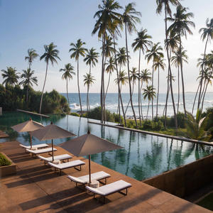 Poolside loungers overlook an infinity pool and Indian Ocean at Amanwella, Sri Lanka.
