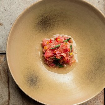 Indonesian dish of diced tomato and herbs on a pale ceramic plate at Amanjiwo's dining room.