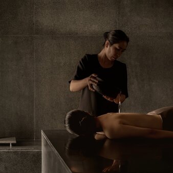 Therapist performing a hammam treatment on a guest's leg at Amanoi spa in Vietnam.