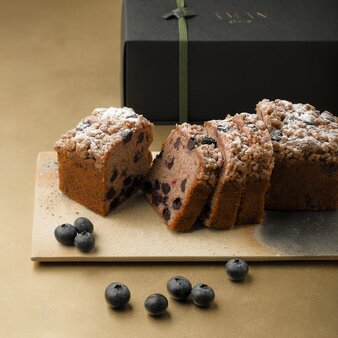 Blueberry pound cake dusted with icing sugar at Aman Kyoto resort, with fresh blueberries scattered on the plate.