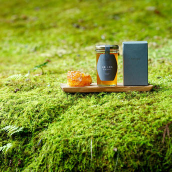 Spa bottles and natural bath products displayed on vibrant moss at Aman Kyoto.