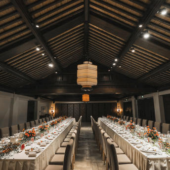 Long dining table set for a celebration at Amanfayun, with lantern lighting and vaulted ceiling.