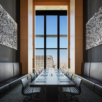Sala riunioni con tavolo in legno e sedie, finestre che affacciano sulla città di Tokyo, Aman Tokyo.