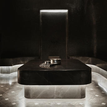 Hammam at Aman New York with dark stone basin and soft ambient lighting
