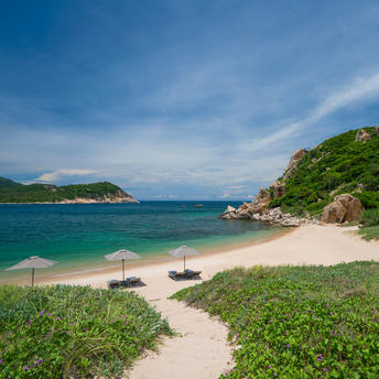 Amanoi's private beach with white sand, turquoise waters and verdant hillsides along Vietnam's coast.