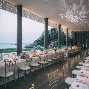 Amanoi's private beach dining pavilion set for an event at dusk, overlooking the coastline.