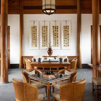 Wooden tea house interior at Amandayan with calligraphy scrolls and traditional furnishings.