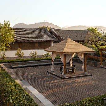 Wooden pavilion on a terrace at Amandayan, with mountain views and surrounding gardens.
