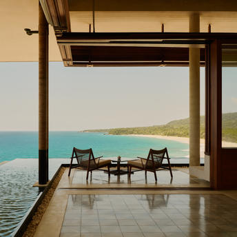 Amanera Casa Grande terrace with two chairs overlooking turquoise ocean and coastline.