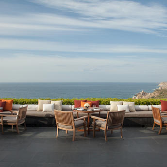 Main restaurant terrace at Amanoi overlooking the sea, with dining tables and coastal views.