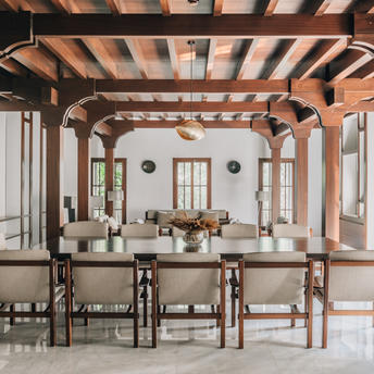 Dining room at Amanyura with exposed wooden beams, natural light, and wooden furniture.