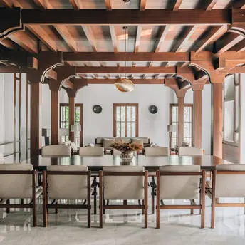 Dining room at Amanyura with exposed wooden beams, natural light, and wooden furniture.