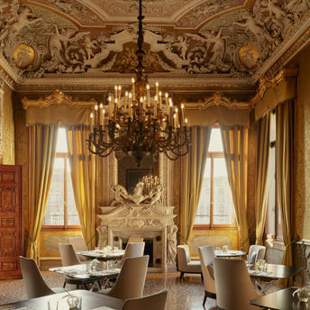 Salle à manger ornée aux plafonds dorés et lustre en cristal, Aman Venice.