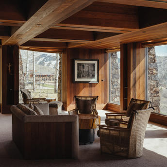Library at Amangani with exposed timber beams, seating areas, and views of surrounding landscape.