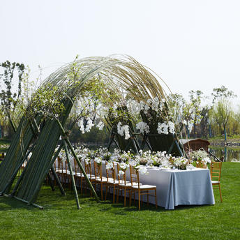 Wedding reception setup at Amanyangyun with draped dome structure and dining table on manicured lawn.