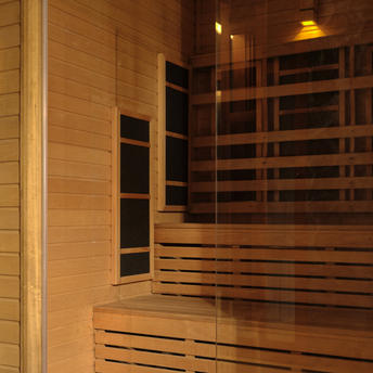 Infrared sauna with wooden benches and warm lighting at Amanpuri resort's spa house.